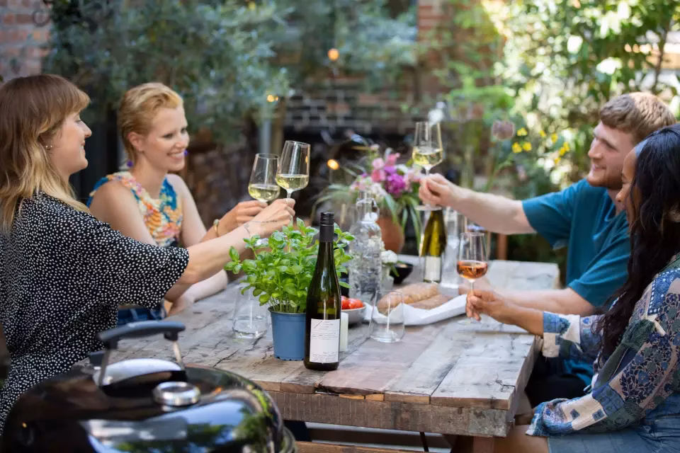 Menschen stossen mit Wein an